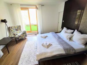 a bedroom with a large bed with two books on it at Apartman Loggia Park & Free Parking in Žilina