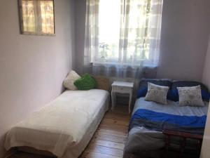 a small room with two beds and a window at Pokoje Wrzeszcz in Gdańsk