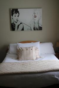 a bed with two black and white pictures above it at New Park Hotel Athenry in Athenry