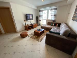 a living room with a couch and a tv at Apartmán Tatran Donovaly Deluxe in Donovaly