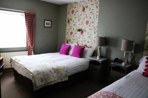 - une chambre avec 2 lits et des oreillers roses dans l'établissement New Park Hotel Athenry, à Athenry