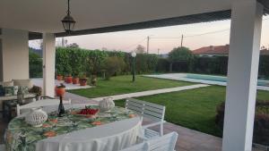 un patio con tavolo, sedie e piscina di Quinta do Soldado ad Albergaria-a-Velha