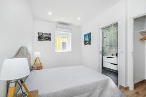 una camera bianca con letto e bagno di Maredimo Village Porto Casa 2 a Porto