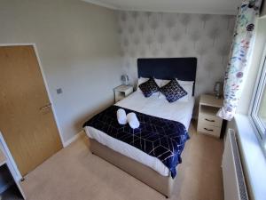 The Deneb في Amotherby: غرفة نوم عليها سرير وعليها حذان ابيض