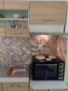 a small kitchen with a sink and a microwave at DOWNTOWN Mavili's Studio in Corfu Town