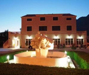 ein Gebäude mit einem Brunnen vor einem Gebäude in der Unterkunft Villa Dubelj Dubrovnik in Mokošica