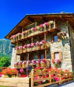 a building with lots of flower boxes on it at La Maison de Clémence in Saint-Rhémy-en-bosses