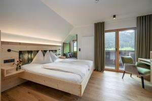 sypialnia z dużym łóżkiem i dużym oknem w obiekcie Hotel Winkler-Tuschnig w mieście Weissensee