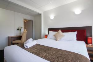 a bedroom with a large white bed and a desk at Ascotia Off Queen in Auckland +56 photos