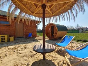 een tafel en stoelen onder een parasol op een strand bij Ośrodek Wypoczynkowy IGOR nad Jeziorem Żywieckim in Żywiec