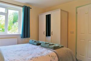 a bedroom with a bed with towels on it at The Cottage Garden - A Herefordshire Retreat in Ross on Wye