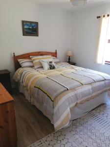 a bedroom with a large bed with pillows on it at Harbourside House Glengarriff in Glengarriff
