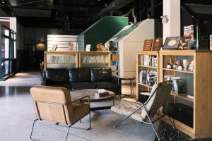 a living room with a black couch and chairs at URSIDE Hotel Shanghai The Bund in Shanghai