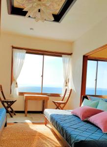 a bedroom with a bed and a large window at AKUA inn in Awaji