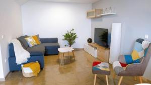 een woonkamer met een blauwe bank en een tv bij Casa La Xiqueta Playa,160m2,Vistas al mar+WIFI in Peñíscola