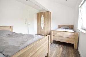 a bedroom with two wooden beds and a mirror at Moderne Ferienwohnung mit Sat-TV & WLAN in Leverkusen