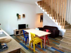 São Miguel de AchaにあるCASAS BEM HAJA Praça e Oliveiraのリビングルーム(テーブル、カラフルな椅子付)