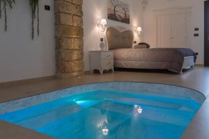 una grande piscina blu in una stanza con un letto di Donna Fiora Antica Dimora ad Alliste