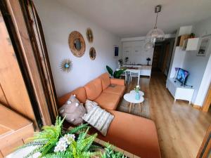 sala de estar con sofá marrón y cocina en Apartamento de montaña y ESQUÍ en el Pirineo Aragonés, Villanúa - WIFI, en Villanúa