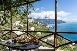 una mesa en un balcón con vistas al océano en Villa Rina en Amalfi