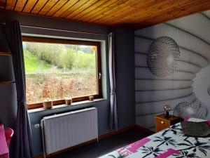 una camera con finestra in una stanza con un letto di Chez YOYO a Stavelot