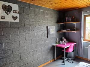 una scrivania rosa contro un muro di mattoni di Chez YOYO a Stavelot