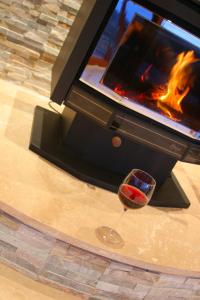 a glass of wine sitting in front of a fireplace at Almonta Park Lodge in Coffin Bay