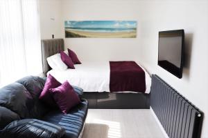 a bedroom with a bed and a couch in front of it at Studio 5 in Woolacombe