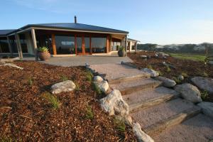 a house with a set of stairs in front of it at Almonta Park Lodge in Coffin Bay