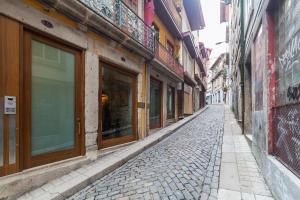 eine Kopfsteinpflasterstraße in einer Gasse mit Gebäuden in der Unterkunft Go2Oporto - Historical Center in Porto