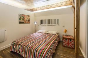 a bedroom with a bed with a striped comforter at Go2Oporto - Historical Center in Porto