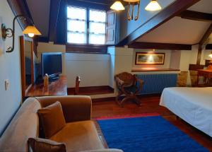 a living room with a bed and a tv at Hotel Eutimio in Lastres