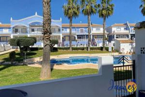 a large apartment building with a swimming pool and palm trees at Laguna Townhouse overlooking Communal Pool LOM01 in Ciudad Quesada