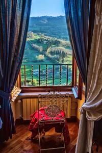 a room with a chair and a large window at Ripa Medici, camere con vista e parcheggio incluso in Orvieto