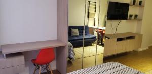 a living room with a red chair and a mirror at Monoambiente de Lujo en Equipetrol - You in Santa Cruz de la Sierra