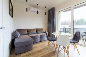 a living room with a couch and a table and chairs at VineWood Apartment, By Cohost in Palanga