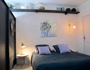 ein Schlafzimmer mit einem Bett und einem Wandgemälde in der Unterkunft les Lauriers in Caromb