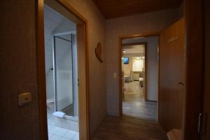 a hallway with a glass door leading to a bathroom at Gasthof Roseneck in Wallenfels