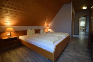 Cama grande en habitación con techo de madera en Gasthof Roseneck, en Wallenfels