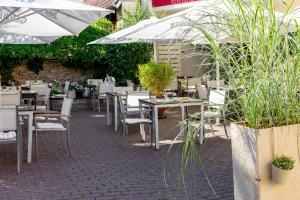 un restaurante al aire libre con mesas, sillas y sombrillas en Scheid´s Hotel – Restaurant en Wasserliesch