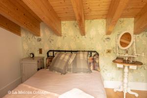 a bedroom with a bed and a wooden ceiling at La Melosa Cottage in Cudillero