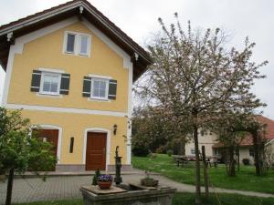 a yellow house with a picnic table in the yard at Ferienhaus Mühlfeldner in Laufen