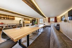 Il dispose d'une cuisine et d'un salon avec une table et des chaises en bois. dans l'établissement STAUDACH - Alpinresidenz Zillertal, à Ramsau im Zillertal