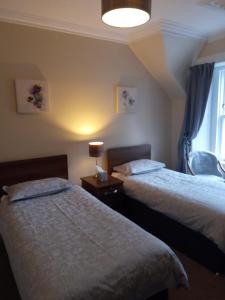 Un pat sau paturi într-o cameră la Fassfern Guesthouse