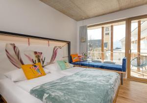sypialnia z dużym łóżkiem i dużym oknem w obiekcie Hotel Blü Gastein w mieście Bad Hofgastein