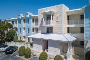 a large apartment building with cars parked in a parking lot at LIC Mgr - LUXURIOUS 2 BED 3 BATH PENTHOUSE SUITE - PANORAMIC OCEAN VIEWS! INDOOR PICKLEBALL - SPEAKEASY! in Key Largo