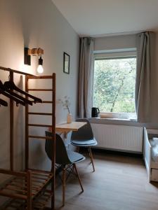Zimmer mit einem Tisch, Stühlen und einem Fenster in der Unterkunft Waldjugendherberge Uelsen in Uelsen