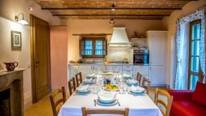 comedor con mesa y mantel blanco en Casa Elia 6, Emma Villas, en San Casciano dei Bagni