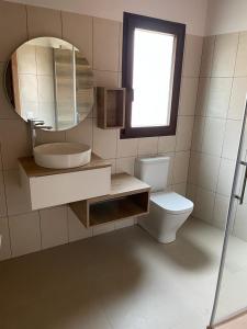 a bathroom with a sink and a toilet and a mirror at CASA LA ABUELA in Olocau del Rey