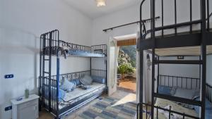 1 Schlafzimmer mit 2 Etagenbetten mit blauen Kissen in der Unterkunft CASA NOEMI 4&2, Emma Villas in Positano